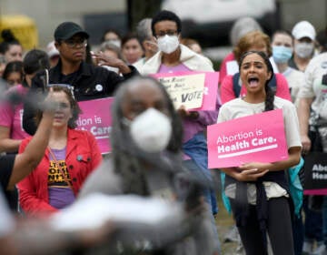 Chandler Jones, right, 26, from Baltimore County who will graduate this spring from the University of Baltimore School of Law, participates in a pro-choice rally in Baltimore, Saturday, May 14, 2022. (AP Photo/Steve Ruark)
