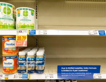 Baby formula is visible on the shelves of a grocery store.
