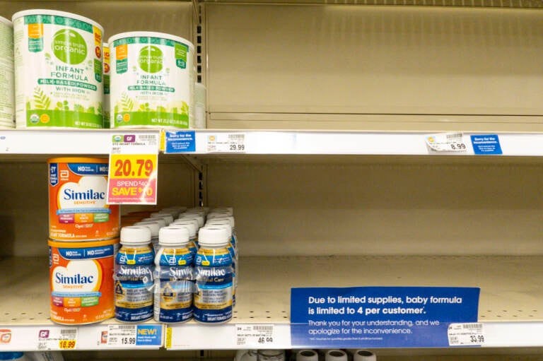 Baby formula is visible on the shelves of a grocery store.