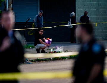 A person places flowers outside the scene of a shooting at a supermarket in Buffalo, N.Y., Sunday, May 15, 2022.