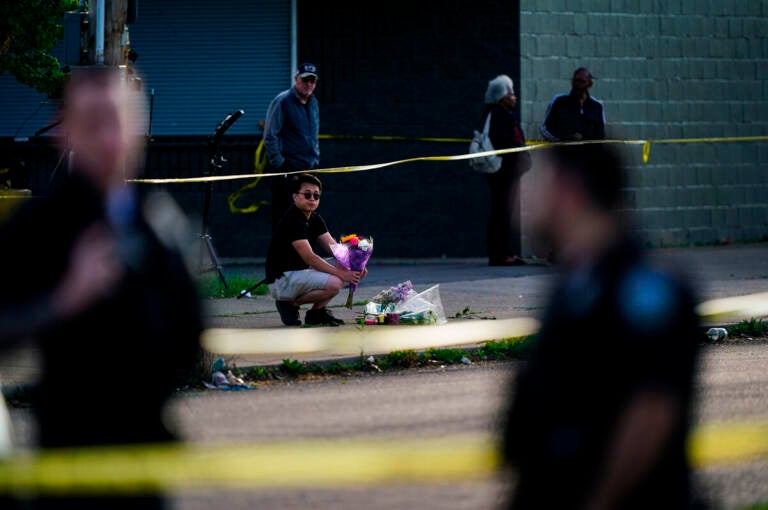 A person places flowers outside the scene of a shooting at a supermarket in Buffalo, N.Y., Sunday, May 15, 2022.