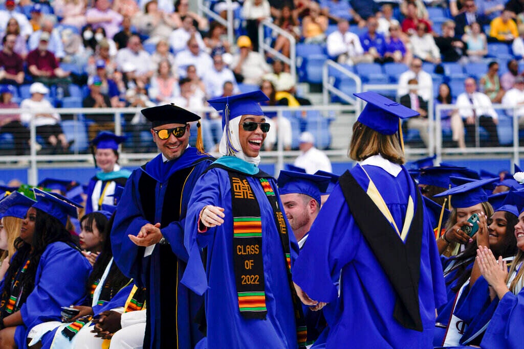 A graduate celebrates, smiling, during the commencement ceremony at the University of Delaware.