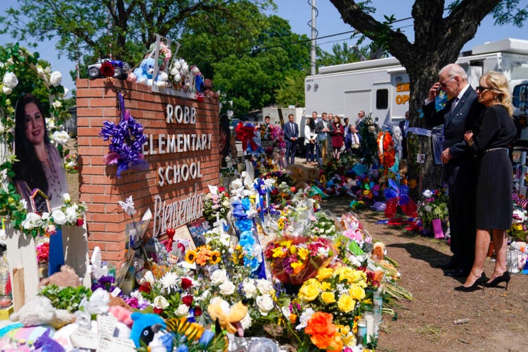 President Joe Biden and First Lady Jill Biden stand in front of a memorial to the victims of the mass shooting in Uvalde, Texas.