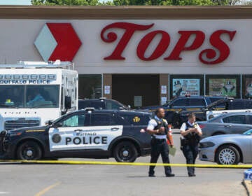 Police walk outside the Tops grocery store following a mass shooting