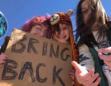 Students are seen holding. a sign that says ''Bring Back''