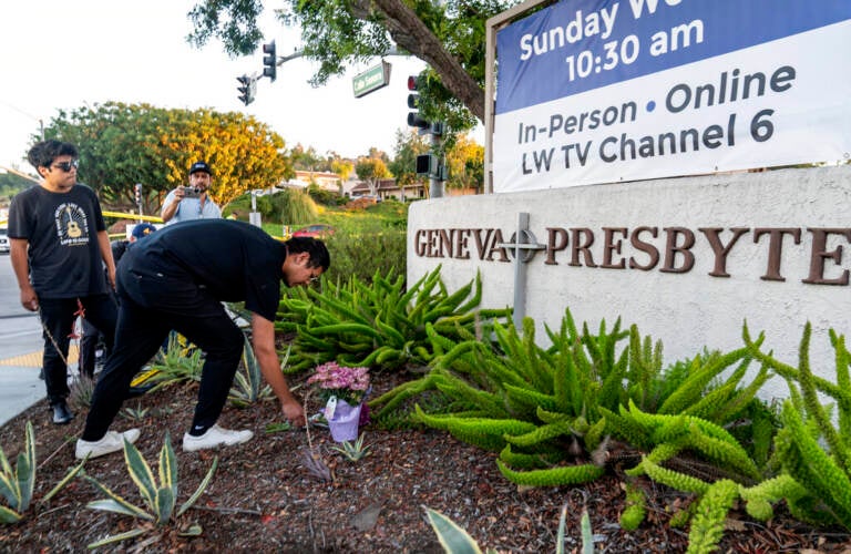 Hector Gomez, left, and Jordi Poblete, worship leaders at the Mariners Church Irvine, leave flowers outside the Geneva Presbyterian Church in Laguna Woods, Calif., Sunday, May 15, 2022, after a fatal shooting.