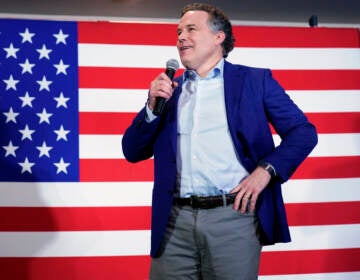 Dave McCormick stands in front of a U.S. flag, with his hand on his hip.