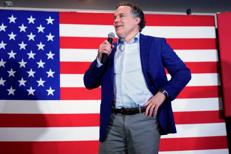 Dave McCormick stands in front of a U.S. flag, with his hand on his hip.