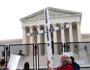 File photo: A demonstrator holding a cross protests outside of the U.S. Supreme Court, Thursday, May 5, 2022, in Washington.