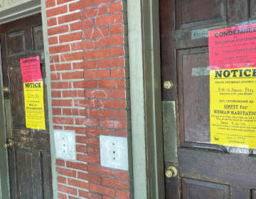 2 front doors with warnings posted on them about condemnation