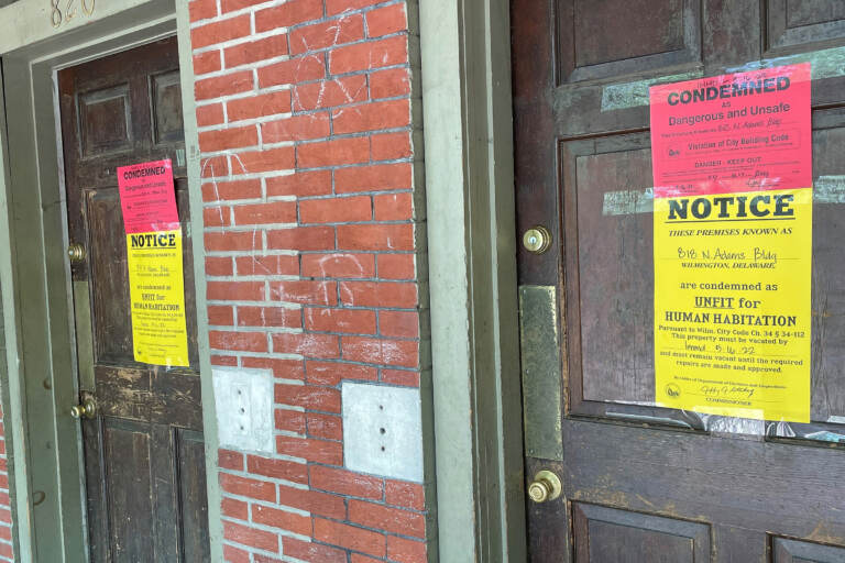 2 front doors with warnings posted on them about condemnation