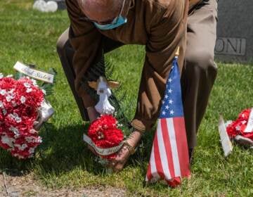 A man puts flower on his wife's grave at Calvary Cemetery on May 10, 2020, in the Queens borough of New York City. Mother's Day can be a painful time, especially for people living with loss. (Jeenah Moon/Getty Images)