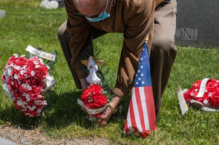 A man puts flower on his wife's grave at Calvary Cemetery on May 10, 2020, in the Queens borough of New York City. Mother's Day can be a painful time, especially for people living with loss. (Jeenah Moon/Getty Images)