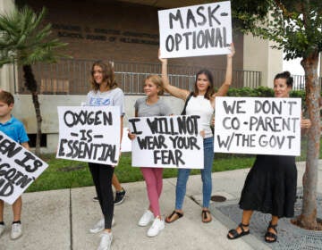 Anger over issues such as the mask mandate galvanized families — like these seen at the Hillsborough County School Board in Tampa, Fla., last year — into running for school board. Progressive groups are taking a leaf out of their playbook. (Octavio Jones/Getty Images)