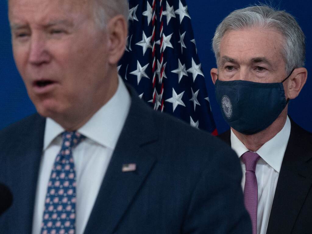 President Joe Biden (left) is seen speaking at a press conference, with Jerome Powell seen wearing a mask behind him