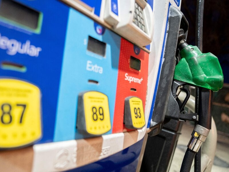 A gasoline pump sits in a holder at an Exxon gas station