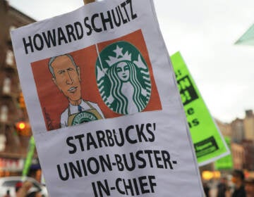A closeup of a protest sign that says ''Howard Schultz Starbucks Union-Buster-In-Chief''