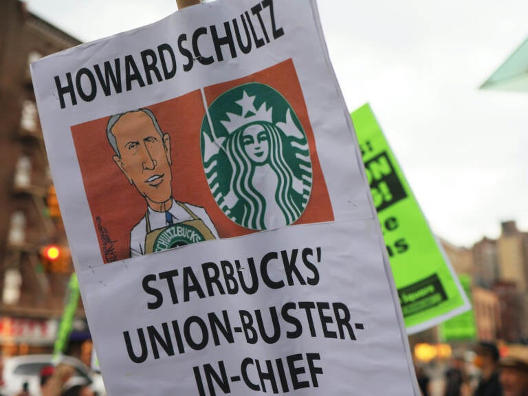 A closeup of a protest sign that says ''Howard Schultz Starbucks Union-Buster-In-Chief''