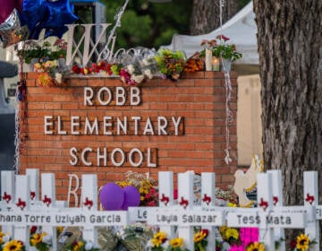 A memorial in front of a sign saying Robb Elementary School.