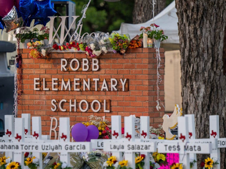 A memorial in front of a sign saying Robb Elementary School.