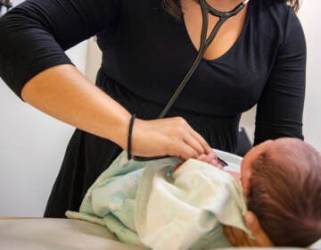 A pediatrician examines a newborn baby