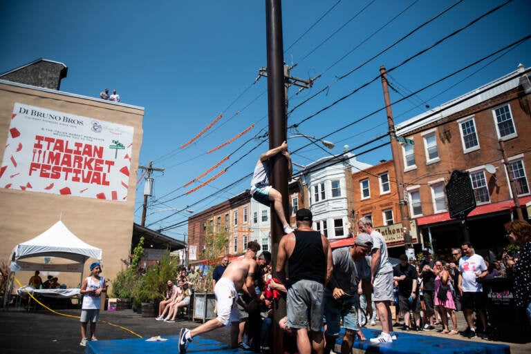 Climbers struggle as their teammates climb on their shoulders during the greased pole competition in Montrose Piazza on Sunday, May 22, 2022.