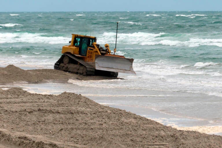 A bulldozer smooths out newly placed sand on an eroded beach in North Wildwood, N.J. on May 24, 2022.  Winter and spring storms caused erosion that will prevent several Jersey Shore beaches from being ready for Memorial Day weekend, but the vast majority of the state's beaches came through the off-season in good condition. (AP Photo/Wayne Parry)