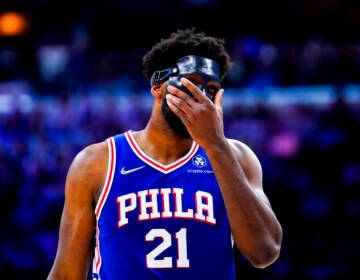 Joel Embiid puts his hand over his face during a playoff game with the Miami Heat.