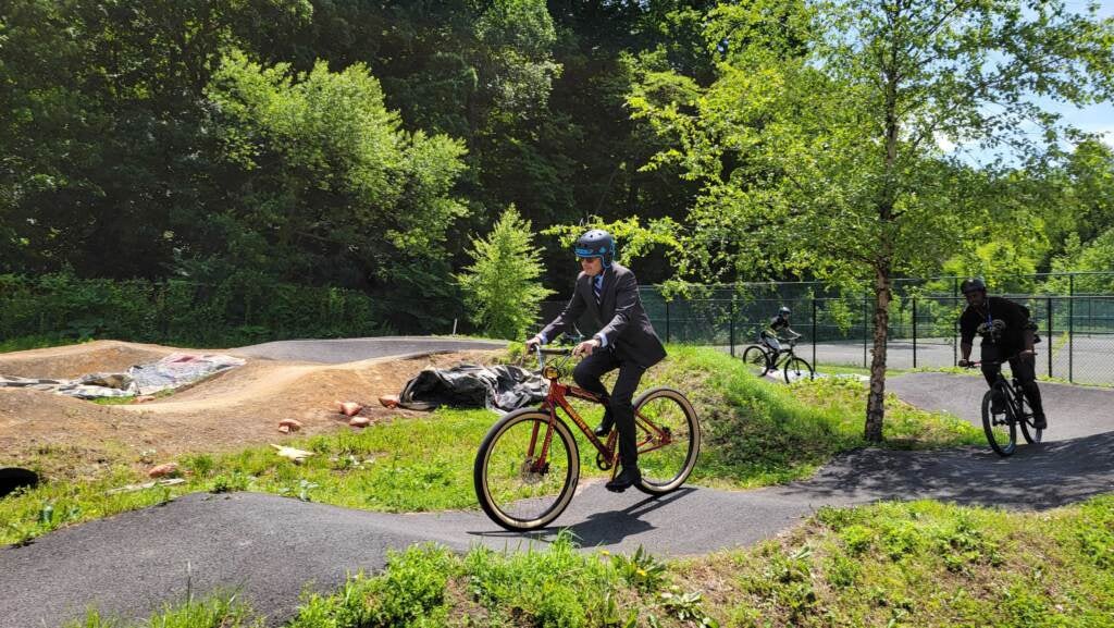 Philly DA Larry Krasner rides a bike on a pumptrack at Philly Pumptrack.