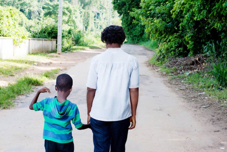 A boy walks with his mother.