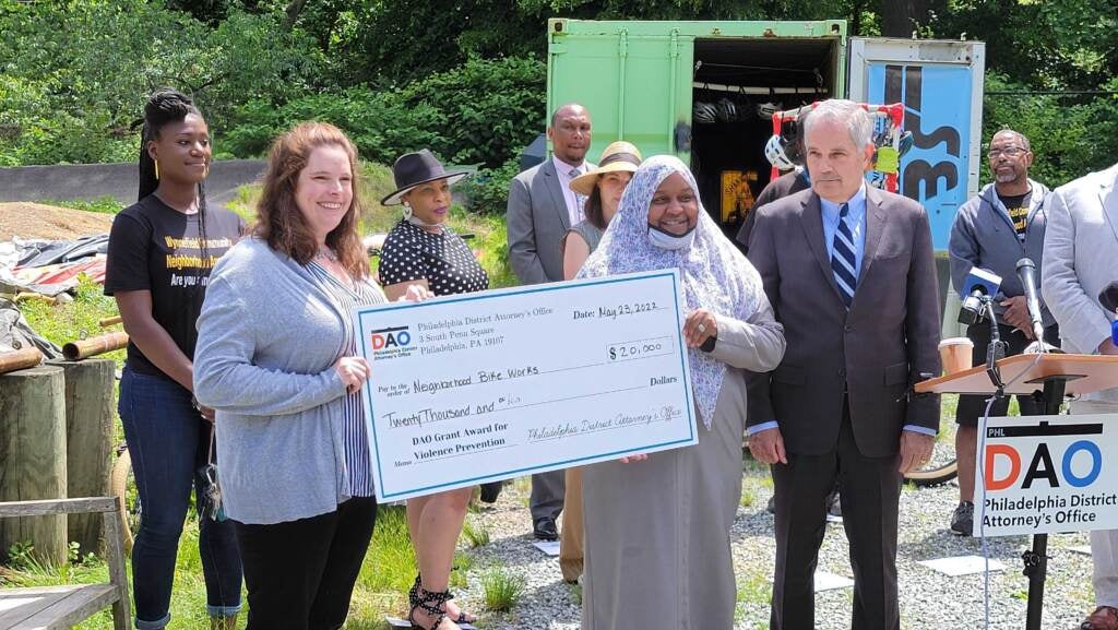 Members of Neighborhood Bike Works pose with a check displaying their microgrant from the DA's Office.