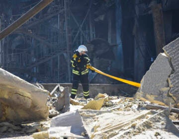 A firefighter walks amid destroyed buildings in Ukraine.