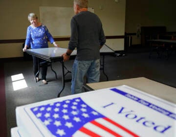 Cecelia Peterson and Dan Pollock move a table at a polling place