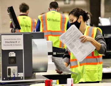 Workers tally mail ballots inside the Pa. Convention Center on Election Day 2020. (Emma Lee/WHYY)