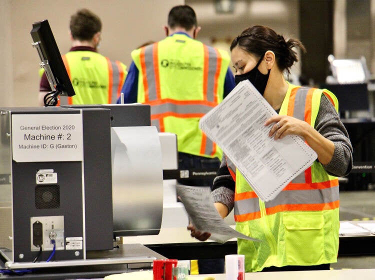 Workers tally mail ballots inside the Pa. Convention Center on Election Day