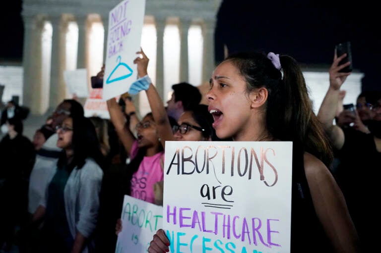 A crowd of people gather outside the Supreme Court protesting a draft opinion regarding Roe v. Wade