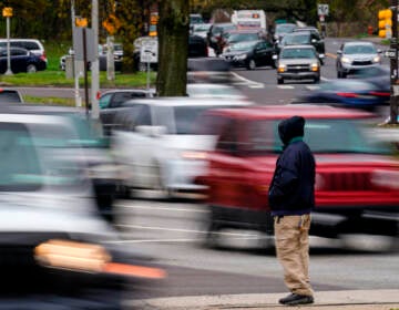 A pedestrian waits to cross Roosevelt Boulevard