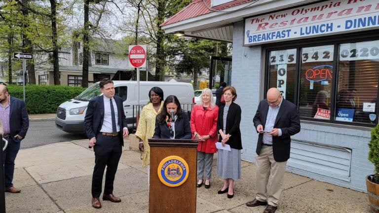 Business members and officials gather outside New Olympia House Restaurant to celebrate small biz week.