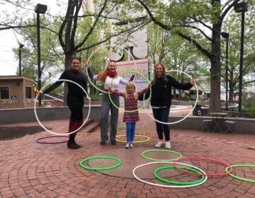 Briana Mitchell and her daughter Pia spent part of Mother's Day learning hula hoop tricks at Spruce Street Harbor Park, with the help of performers Kelsey Lee (far left) and Jennifer Alvarez.