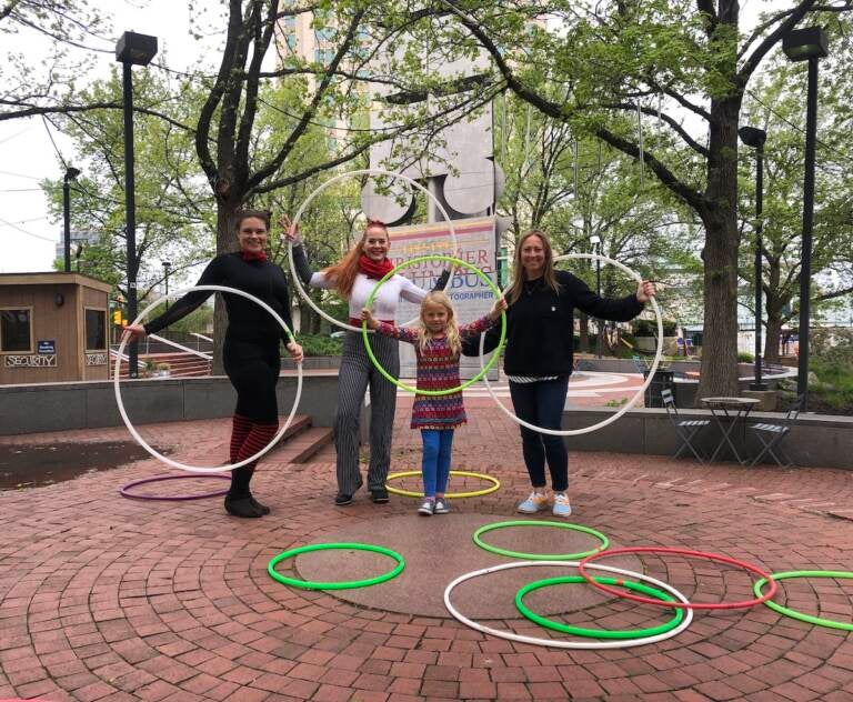 Briana Mitchell and her daughter Pia spent part of Mother's Day learning hula hoop tricks at Spruce Street Harbor Park, with the help of performers Kelsey Lee (far left) and Jennifer Alvarez.