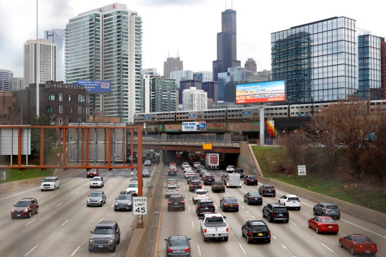 File photo: Traffic flows along Interstate 90 highway as a Metra suburban commuter train moves along an elevated track in Chicago on March 31, 2021. With upcoming data showing traffic deaths soaring, the Biden administration is steering $5 billion in federal aid to cities and localities to address the growing crisis by slowing down cars, carving out bike paths and wider sidewalks, and nudging commuters to public transit.