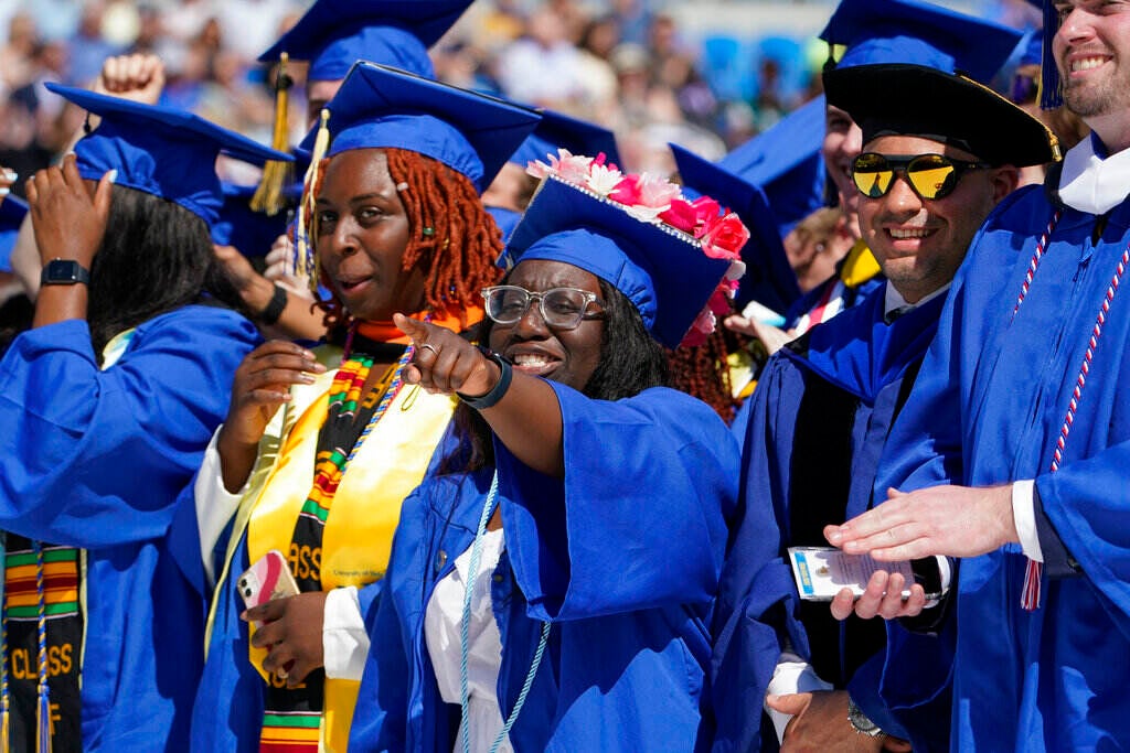 University of Delaware graduates, wearing their gowns and caps, celebrate.