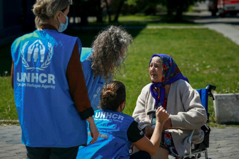 UNCH staff speak to an elderly Ukrainian refugee woman during a visit by U.N. Secretary-General Antonio Guterres to a refugee facility housing Ukrainian refugees in Chisinau, Moldova, Tuesday, May 10, 2022. (AP Photo/Aurel Obreja)