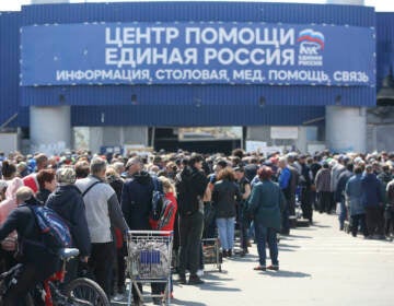 Local civilians line up to get humanitarian aid distributed in the United Humanitarian Center in Mariupol