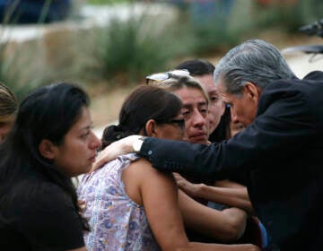 The Archbishop of San Antonio, Gustavo Garcia Seller comforts families outside of the Civic Center in Uvalde