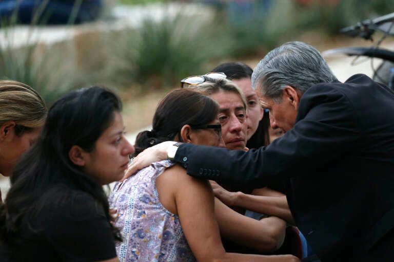 The Archbishop of San Antonio, Gustavo Garcia Seller comforts families outside of the Civic Center in Uvalde