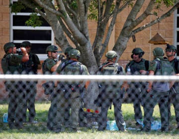 Law enforcement personnel are gathered outside of the school following the mass shooting in Uvalde, Texas.