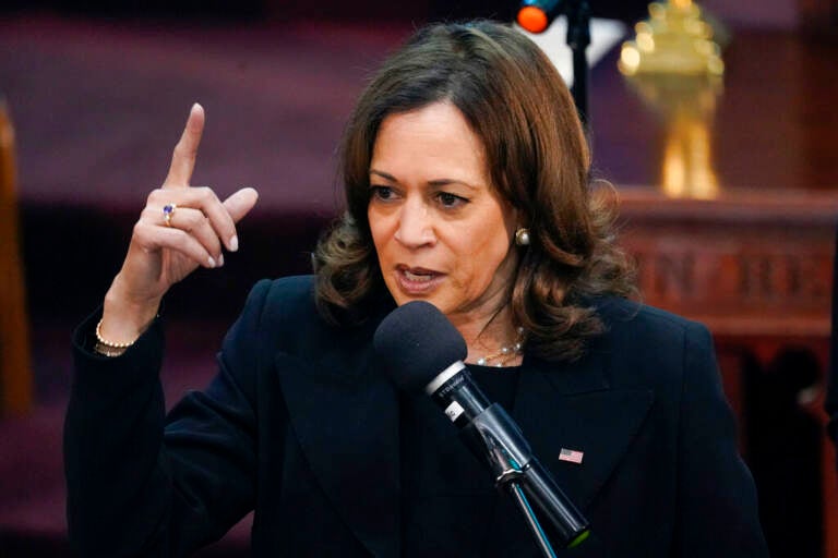 A close-up of Vice President Kamala Harris, dressed in black, pointing emphatically as she speaks at the funeral of one of the victims of the Buffalo shooting attack.