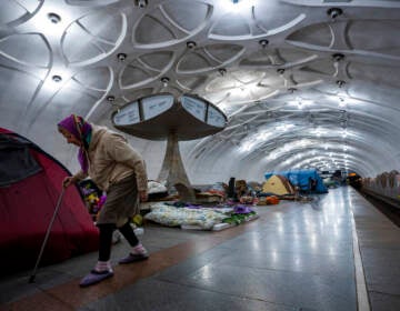 An elderly woman walks inside a metro station being used as a bomb shelter in Kharkiv, Ukraine, Thursday, May 12, 2022.