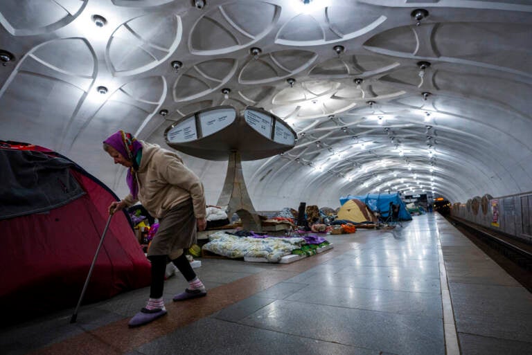 An elderly woman walks inside a metro station being used as a bomb shelter in Kharkiv, Ukraine, Thursday, May 12, 2022.